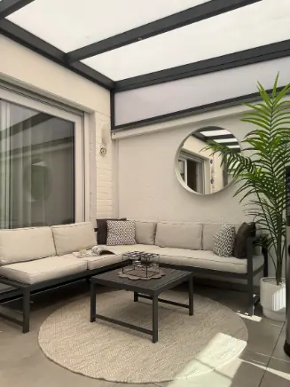 &Uuml;berdachte Terrasse mit moderner Lounge und rundem Teppich.