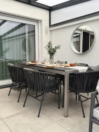 Terrassen-Essgruppe mit gro&szlig;em Tisch und grauen St&uuml;hlen.