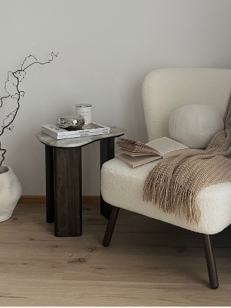 Warm Modern Leseecke mit Sessel und dunklem Beistelltisch Gemütliche Leseecke mit Sessel, Beistelltisch und warmen Naturfarben