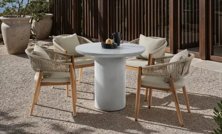 Outdoor-Essgruppe mit rundem Tisch und 4 St&uuml;hlen auf Terrasse im nat&uuml;rlichen Sonnenlicht
